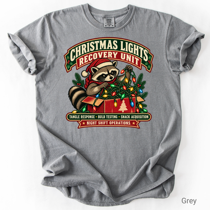 Vintage-style Christmas Lights Recovery Unit design featuring a raccoon in a Santa hat tangled in colorful Christmas lights beside a gift box.